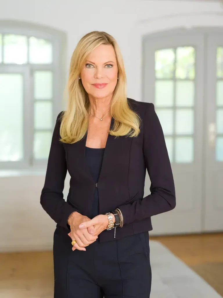 Portrait Nina Ruge in dunkelblauem Hosenanzug in einem hellen Raum mit Rundbogenfenstern, fotografiert von Frank Erpinar